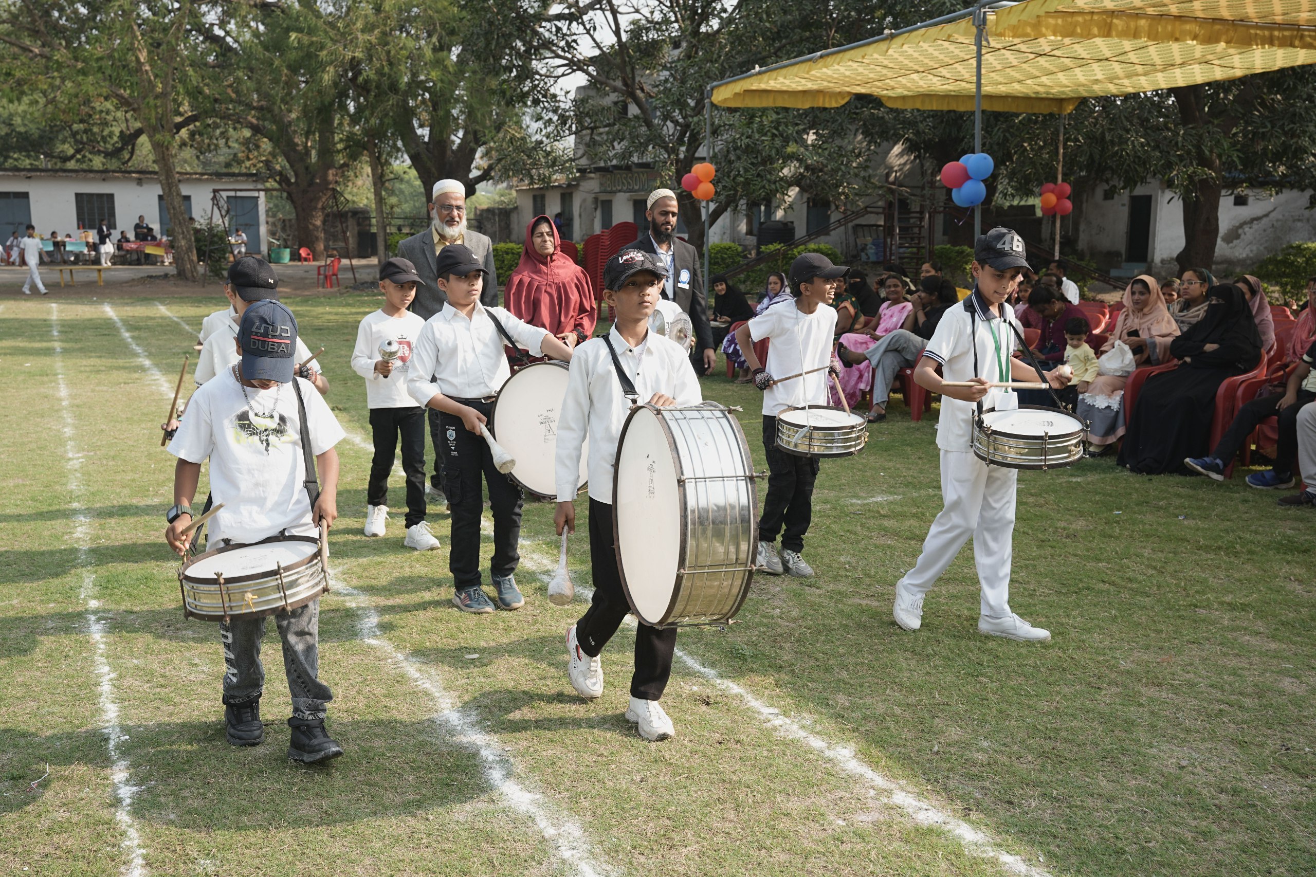 Students playing drums during sports day march-past